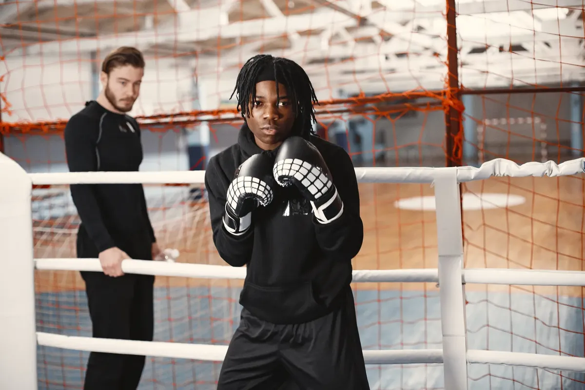 Young athletes training in a boxing ring, focusing on combat sports skills.