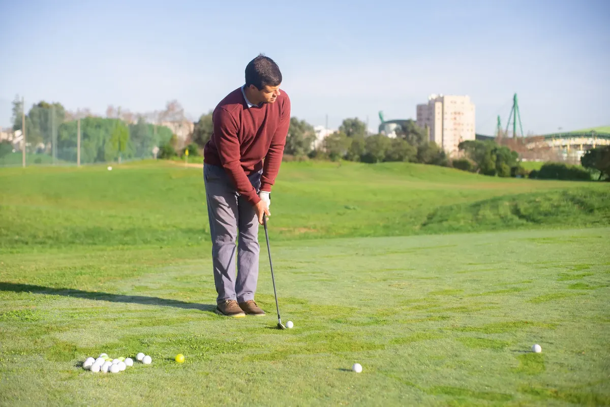 A man playing golf on a lush green course on a sunny day in Portugal.