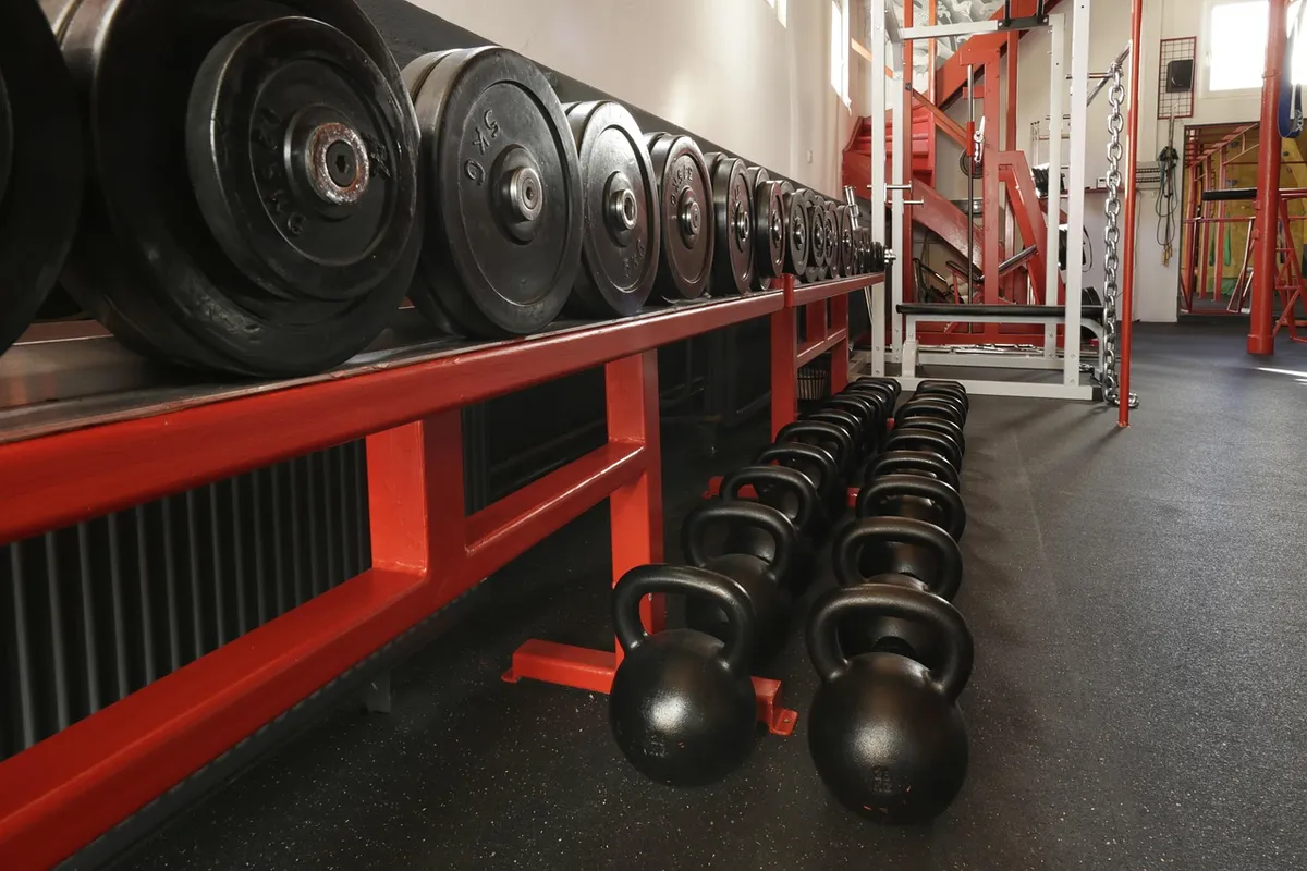 Barbells in sports gym with athlete's hand